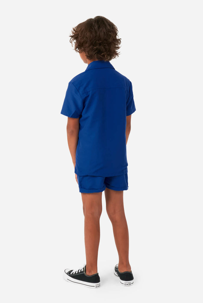 Jongen in donkerblauwe zomerset, bestaande uit korte broek en shirt