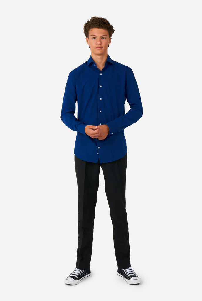 Tiener draagt Blauw overhemd en zwarte broek