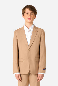 Tienerjongen draagt een stijlvol lichtbruin/beige pak met een wit overhemd en ziet er zelfverzekerd uit. Perfecte formele outfit voor speciale gelegenheden, bruiloften en feesten voor jongens.