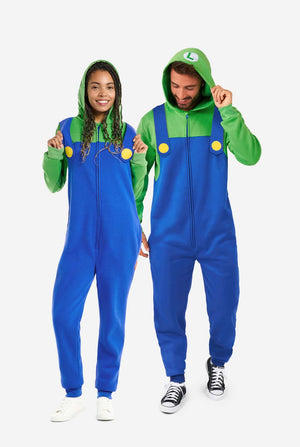 Een man en een vrouw zijn gekleed in een Luigi-thema onesie. De outfit ziet eruit als een felgroene hoodie met een "L"-symbool op de capuchon en een blauwe overall met grote gele knopen op de bandjes. Het algehele ontwerp imiteert de look van het populaire videogamepersonage Luigi, met contrasterende groene en blauwe kleuren. De achtergrond is effen, waardoor de nadruk op het kostuum ligt. Full body image