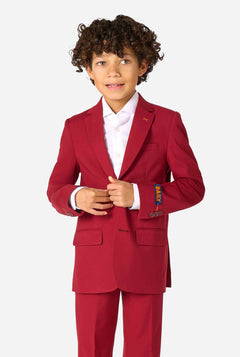 Een kind in een stijlvol bordeauxrood pak met een wit overhemd, dat er zelfverzekerd uitziet. De perfecte formele outfit voor speciale gelegenheden, bruiloften en feestjes voor jongens.