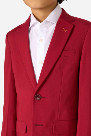 Een kind in een stijlvol bordeauxrood pak met een wit overhemd, dat er zelfverzekerd uitziet. De perfecte formele outfit voor speciale gelegenheden, bruiloften en feestjes voor jongens. Close up van de borst.