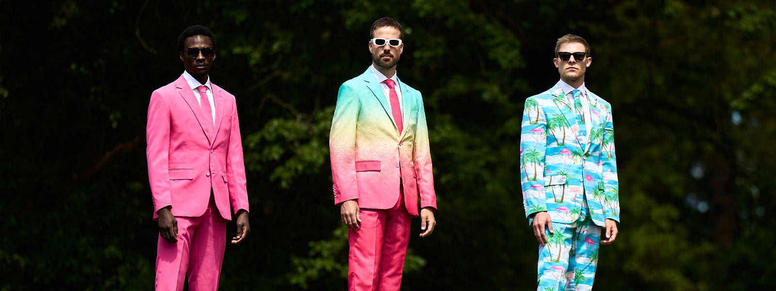 Een afbeelding van drie mannen die naast elkaar staan. De man links draagt een Mr. Pink-pak, de man in het midden een Funky Fade-pak en de man rechts een Flaminguy-pak.