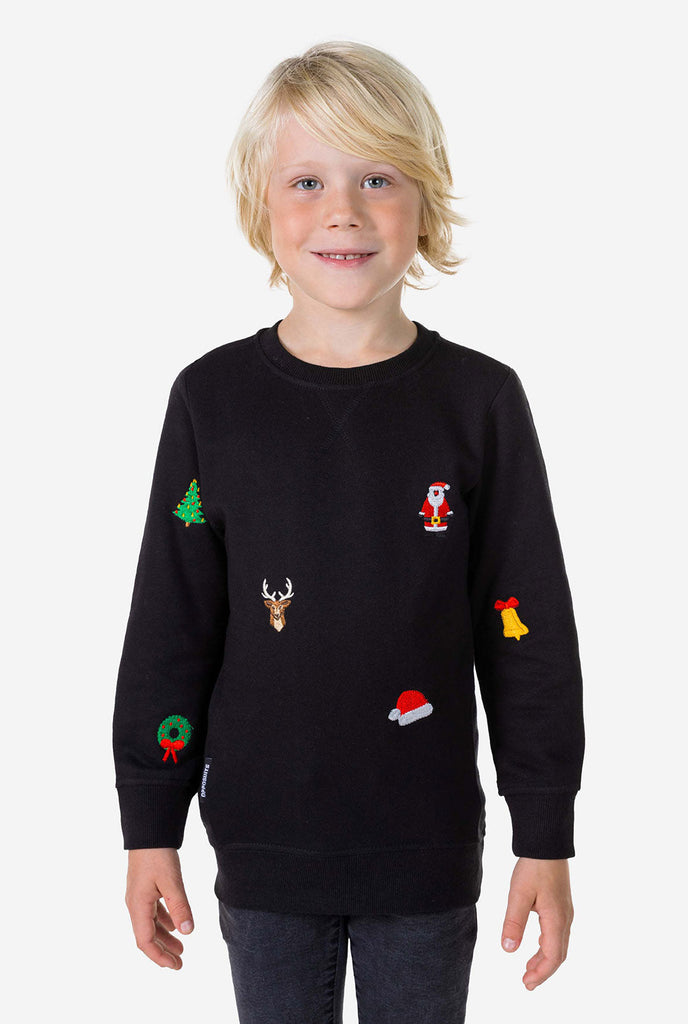 Kind draagt ​​een zwarte kersttrui met kerstpictogrammen