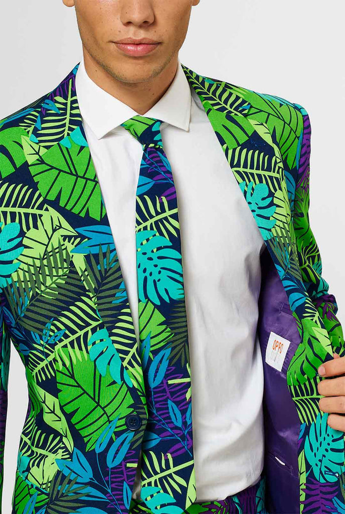 Jungle -pak met groene en paarse bladafdruk door man getoond in de jas