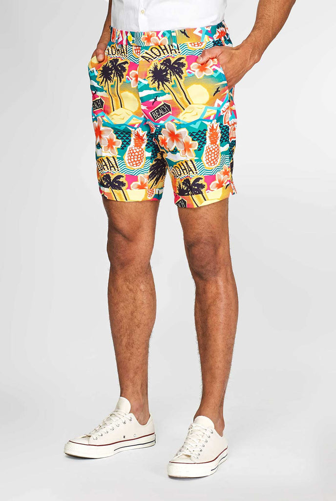 Man draagt ​​een kleurrijk Hawaiiaans print zomerpak, bestaande uit korte, jas en stropdas, close -up van broek