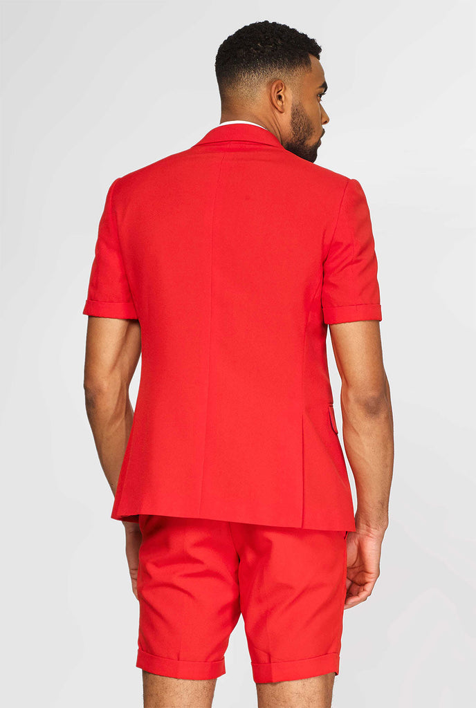 Man draagt ​​een rood zomerpak, bestaande uit shorts, jas en stropdas, uitzicht vanaf de achterkant