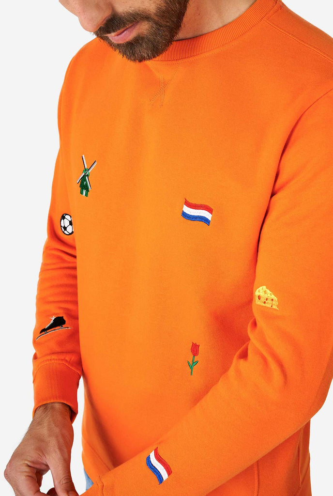 Man draagt ​​een oranje trui met Nederlandse iconen