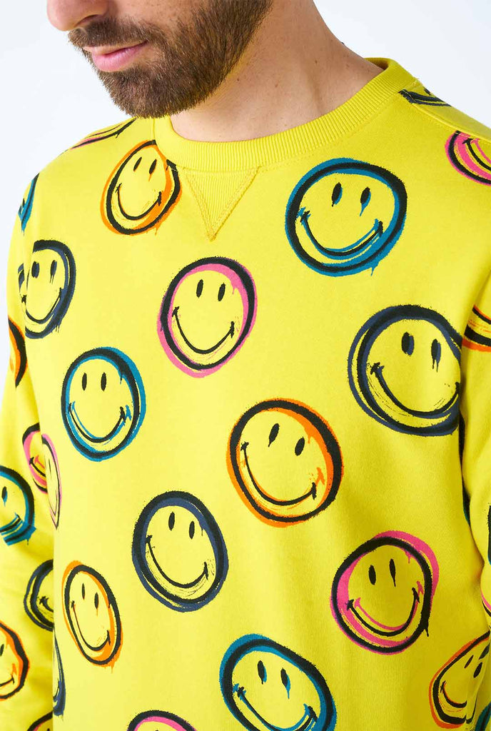 Man draagt ​​gele herentrui met smiley print, close -up