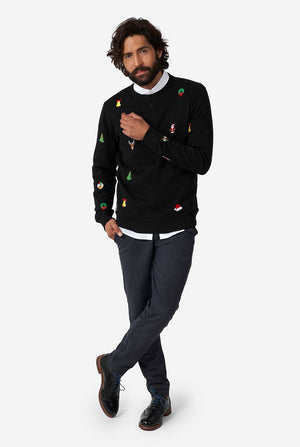 Man draagt een zwarte kersttrui met kersticonen