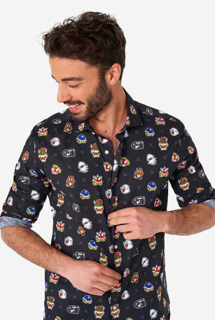 Man draagt ​​een zwart overhemd met Super Mario Bad Guys -iconen