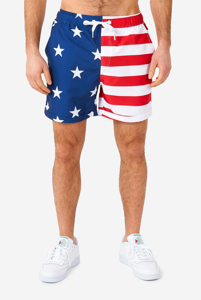 Man draagt ​​zomeroutfit, bestaande uit shirt en shorts, met de Amerikaanse vlaggenprint, shorts close -up