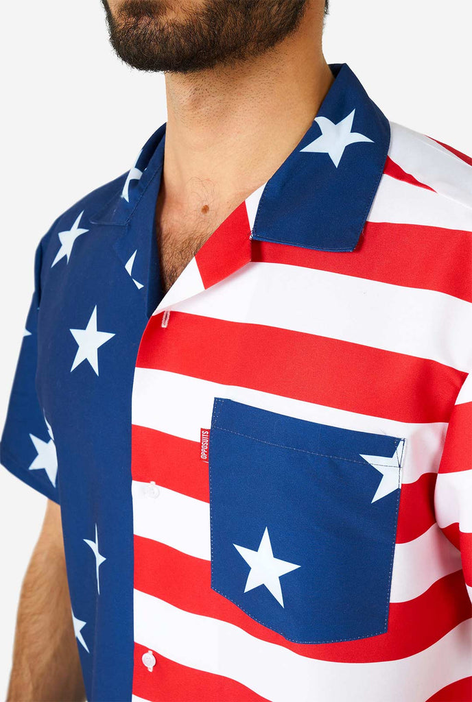 Man draagt ​​zomeroutfit, bestaande uit shirt en shorts, met de Amerikaanse vlaggenprint, shirt close -up