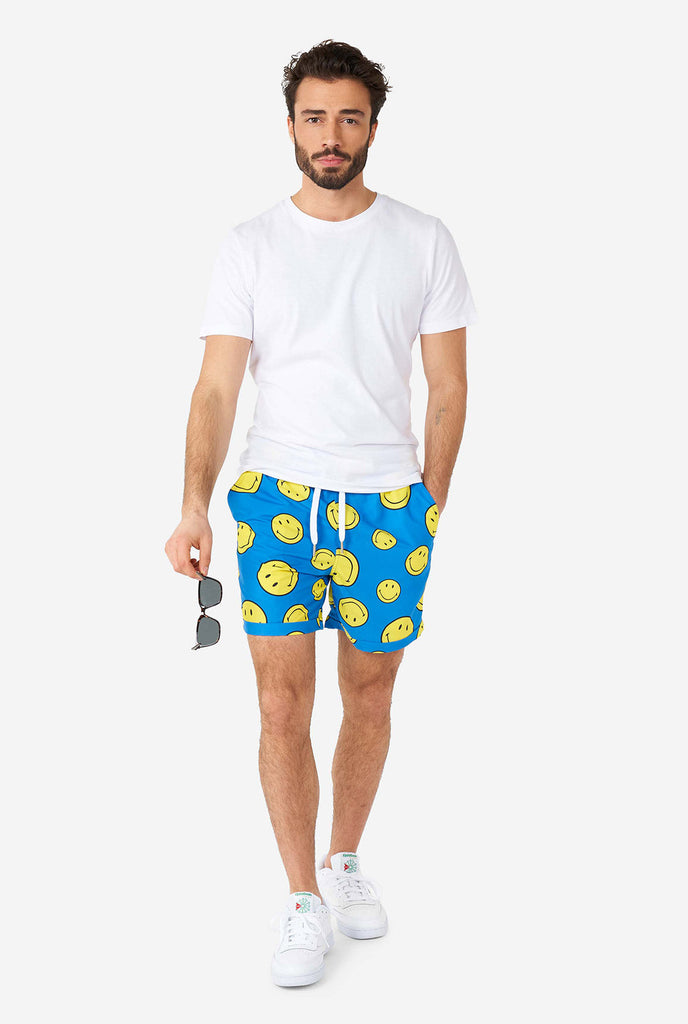 Man draagt ​​een deel van de blauwe zomerset, bestaande uit shorts en shirt, met smiley print