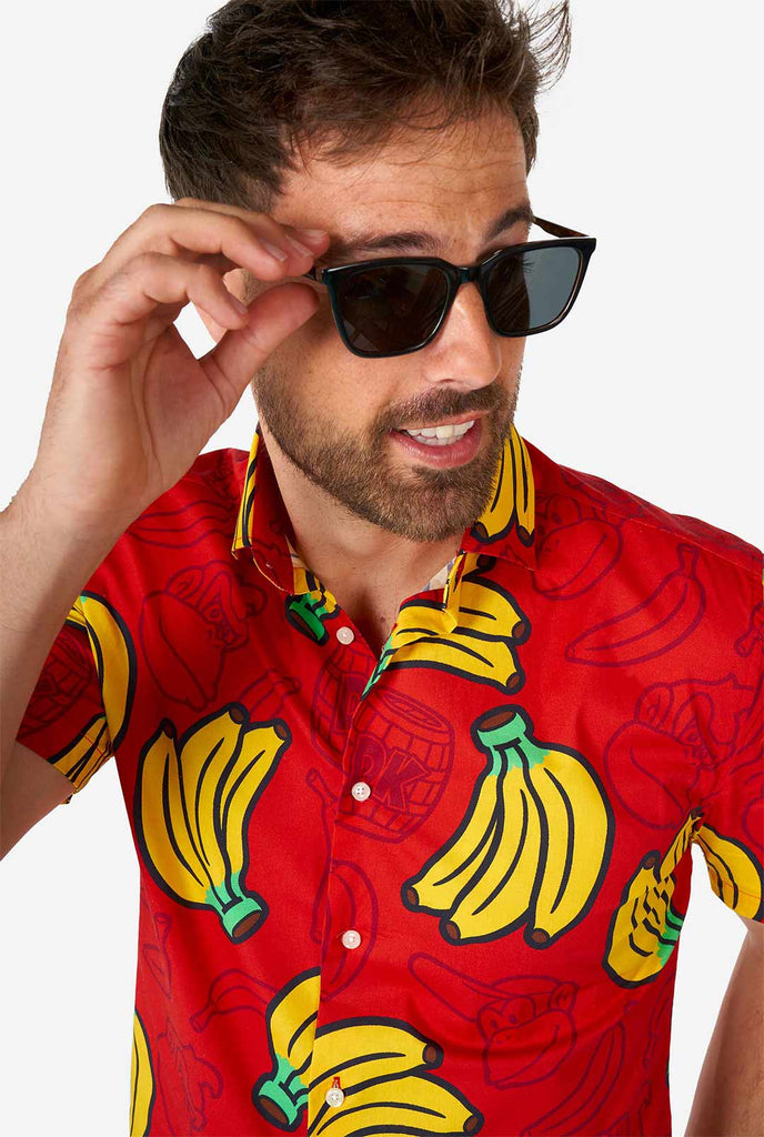 Man draagt ​​een rood zomerhemd met ezel kong print, close -up