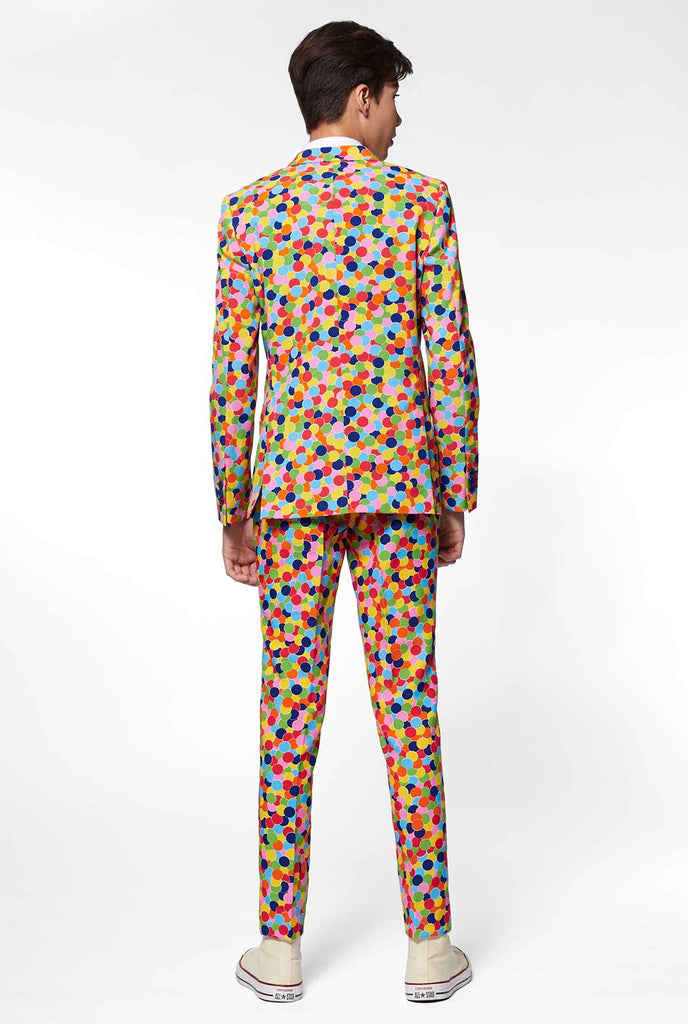 Tiener draagt ​​een formeel pak met confetti -print, bekijk vanaf de achterkant