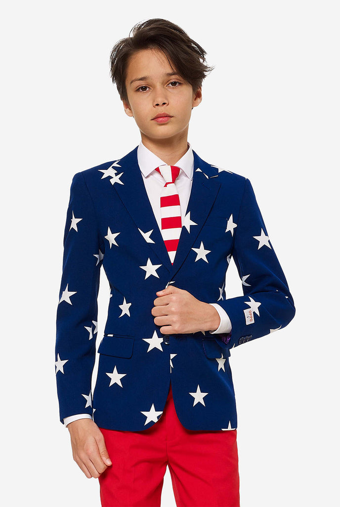 Tiener draagt ​​een formeel pak met de VS op het vierde juli, bestaande uit blauwe jas en rode broek.