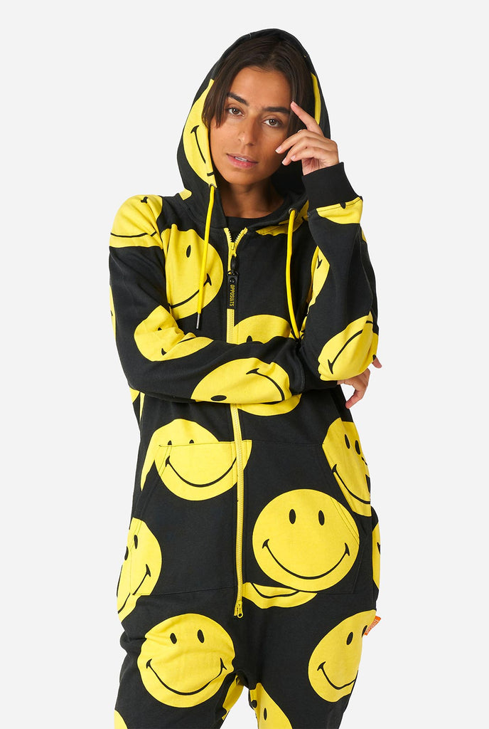 Vrouw draagt ​​zwarte onesie met gele smileyprint