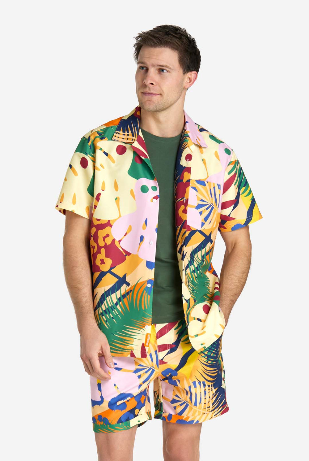 Een man in een tropische zomerset, bestaande uit een kort broekje en een overhemd met knopen