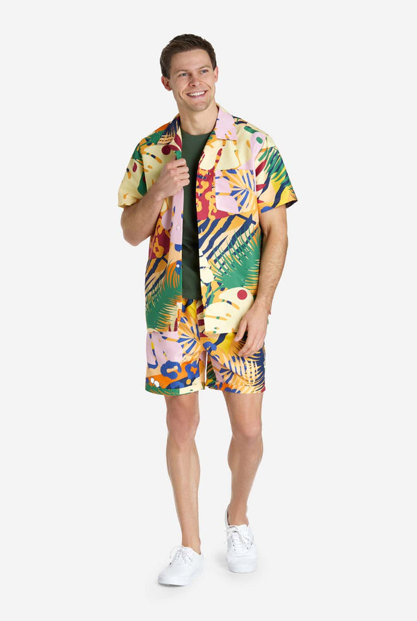 Een man in een tropische zomerset, bestaande uit een kort broekje en een overhemd met knopen