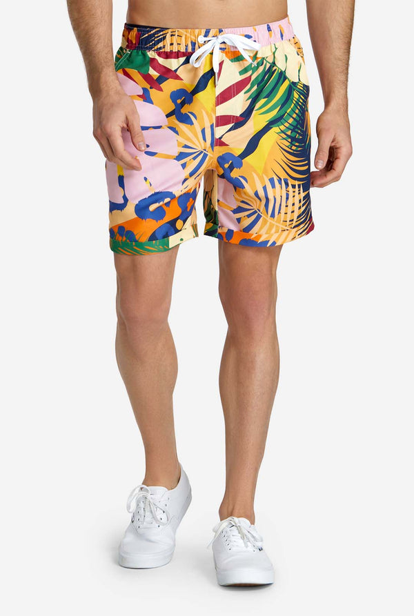 Een man in een tropische zomerset, bestaande uit een kort broekje en een overhemd met knopen