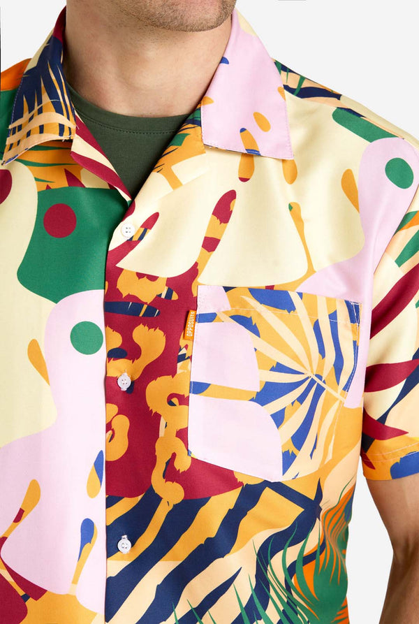 Een man in een tropische zomerset, bestaande uit een kort broekje en een overhemd met knopen