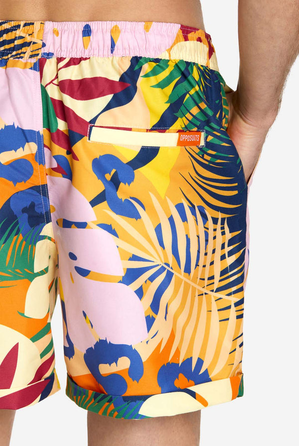 Een man in een tropische zomerset, bestaande uit een kort broekje en een overhemd met knopen
