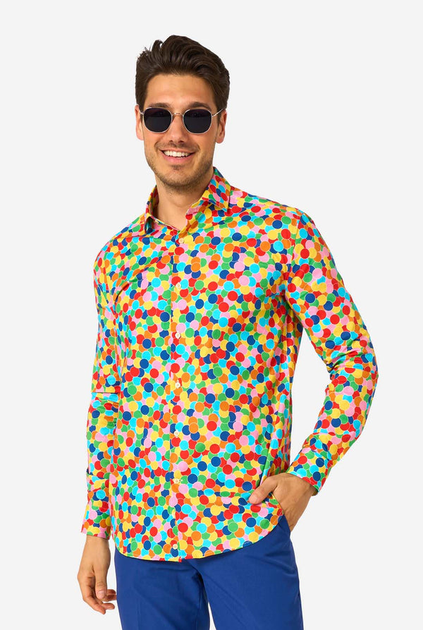 Man met een kleurrijk polka dot confetti-shirt op een witte achtergrond. Draagt een zonnebril
