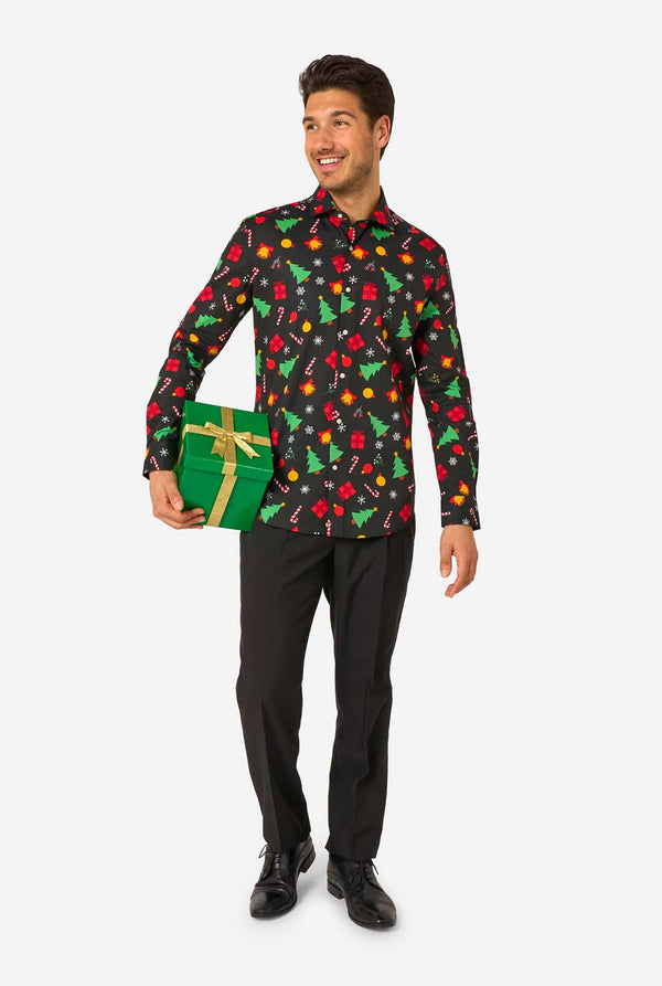 Man met een zwart overhemd met feestelijk patroon en kleurrijke kerstmotieven op een witte achtergrond. Houdt een cadeautje vast, volledig lichaam