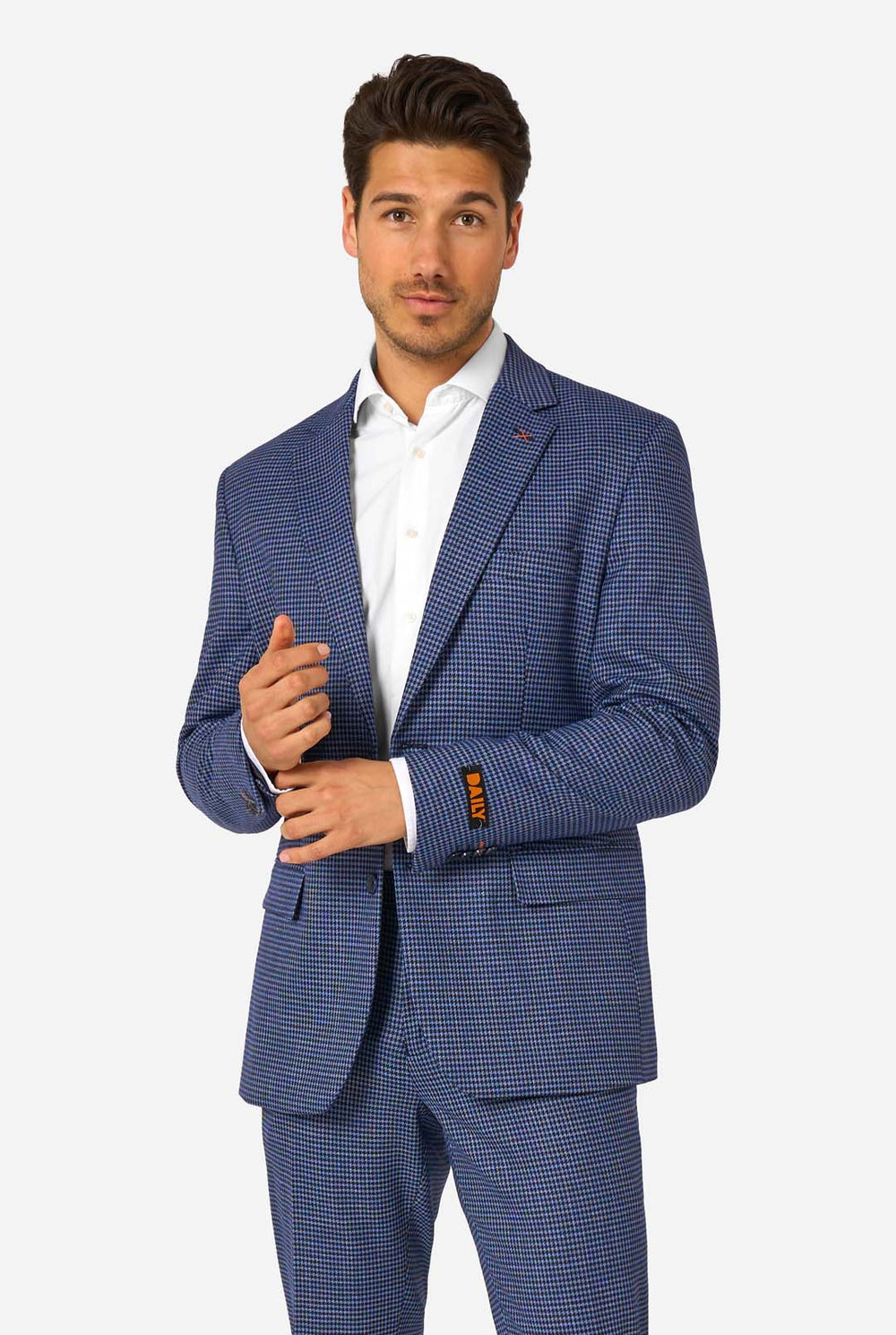 Een man draagt een marineblauw en blauw geruit pak met een wit overhemd. Het pak heeft een moderne pasvorm met twee knopen en klepzakken. Hij staat tegen een effen witte achtergrond.
