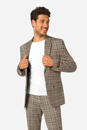 Een man draagt een bruin geruit pak met een wit overhemd. Het pak heeft een moderne pasvorm met twee knopen en klepzakken. Hij staat tegen een effen witte achtergrond.