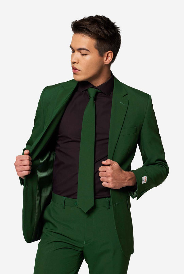 Model toont de binnenvoering van een OppoSuits Glorious Green colbert, gecombineerd met een zwart overhemd en groene stropdas – trendy herenmode.
