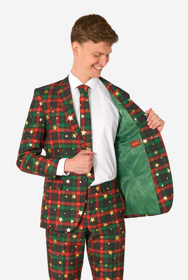 Man in tartan ruitpak met gouden sterrenaccenten houdt de jas open om een effen groene voering met een OppoSuits-label te tonen.