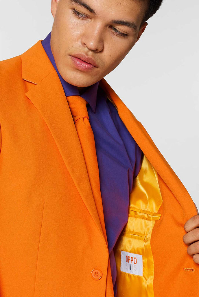 Man wearing orange men's suit with purple dress shirt