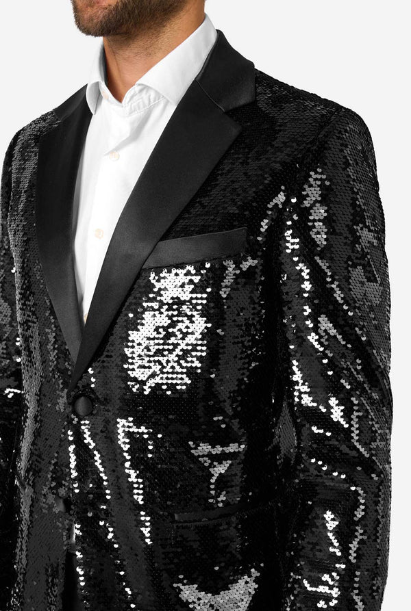 Man draagt ​​een zwart paillettenblazer met een satijnen revers.