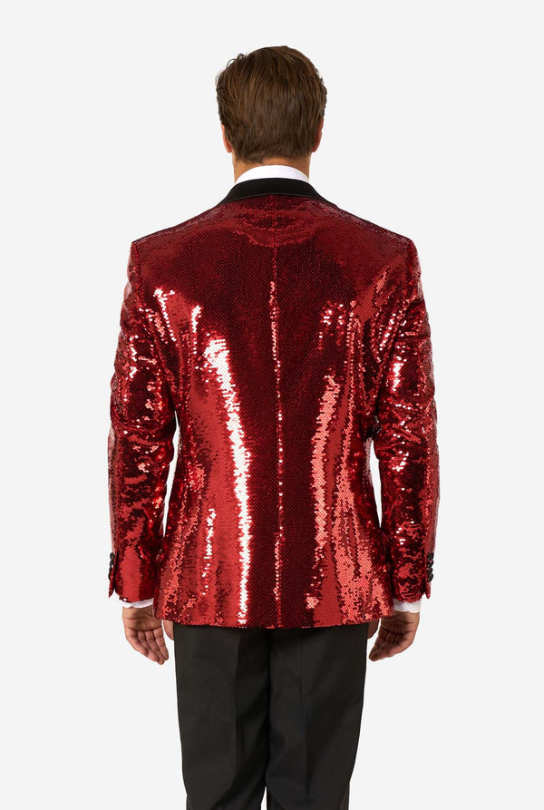 Man draagt een glimmend rode paillettenblazer  met zwarte revers.