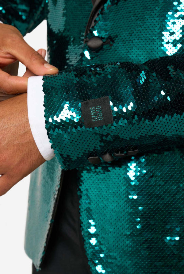 Man draagt ​​een blauwgroene blazer met pailletten en zwarte satijnen revers.