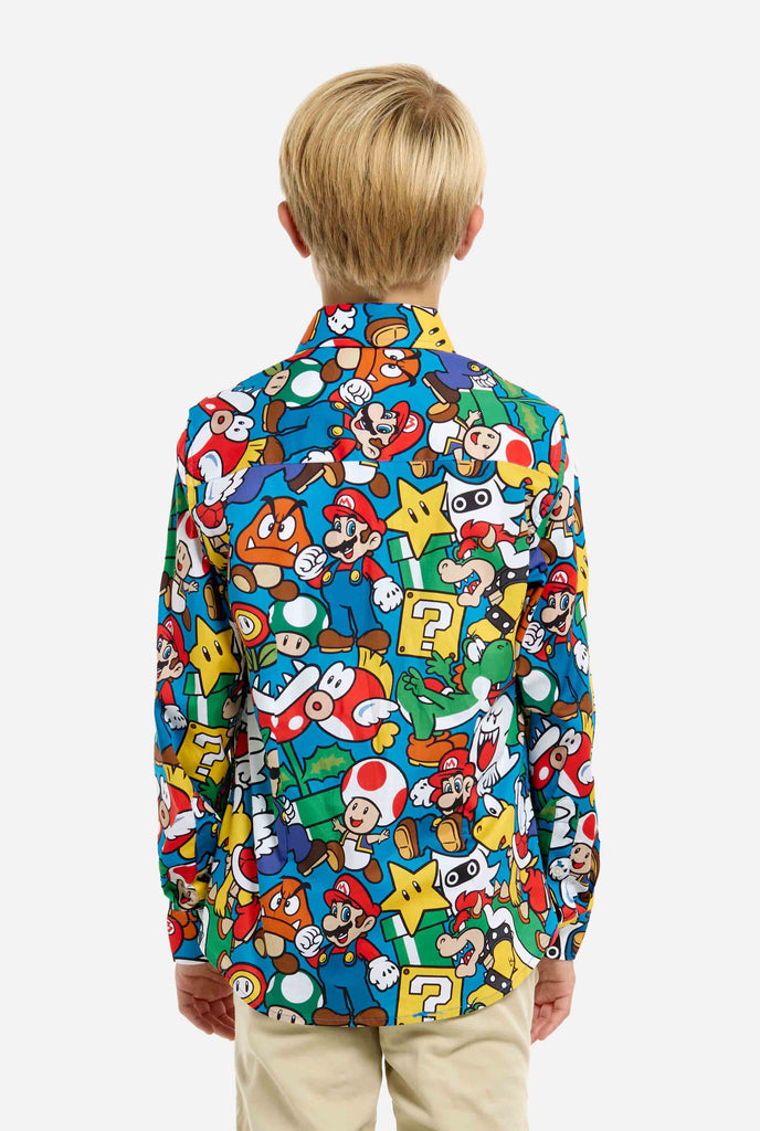 Afbeelding van tiener die een Super Mario all over print shirt draagt. De hoofdkleur is blauw, maar er is ook geel, rood en wit.
