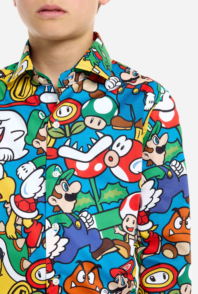 Afbeelding van tiener die een Super Mario all over print shirt draagt. De hoofdkleur is blauw, maar er is ook geel, rood en wit.