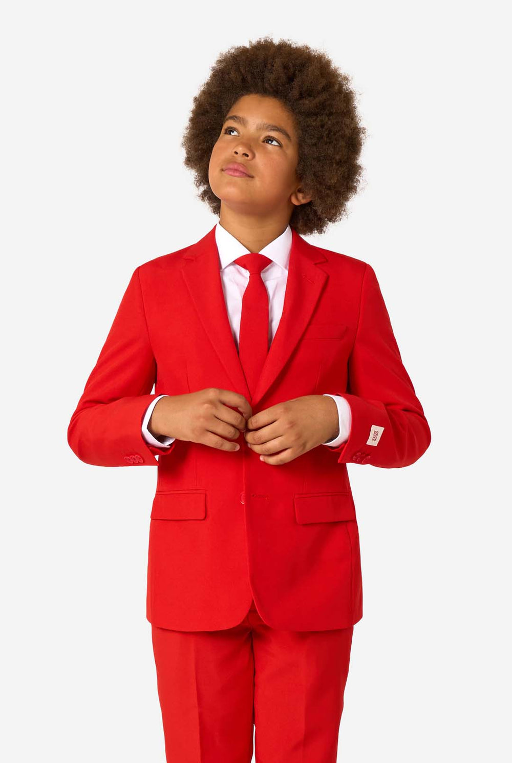 Kind draagt een rood pak met een wit overhemd en een rode stropdas op een witte achtergrond