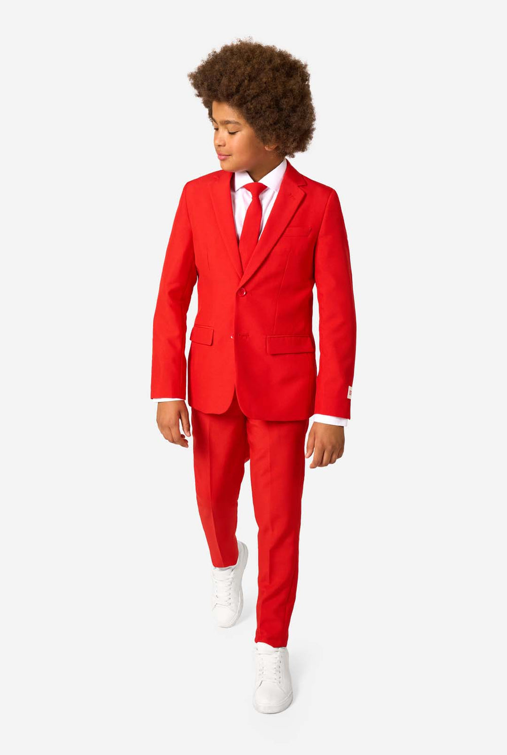 Kind draagt een rood pak met een wit overhemd en een rode stropdas op een witte achtergrond