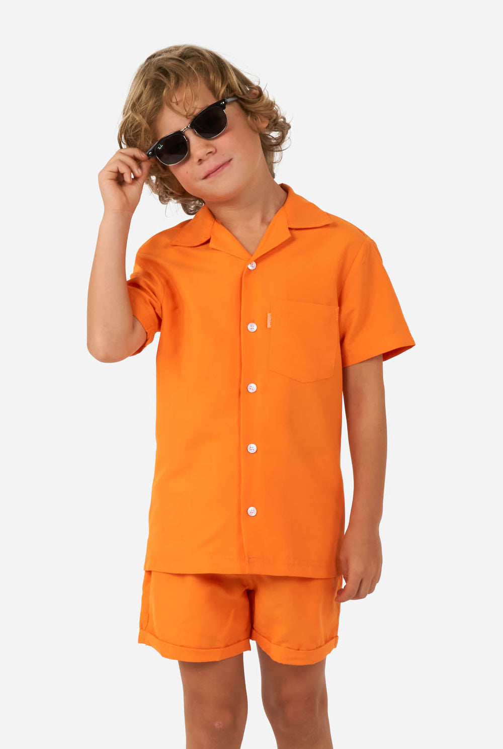 Jongen draagt oranje zomerset, bestaande uit korte broek en shirt