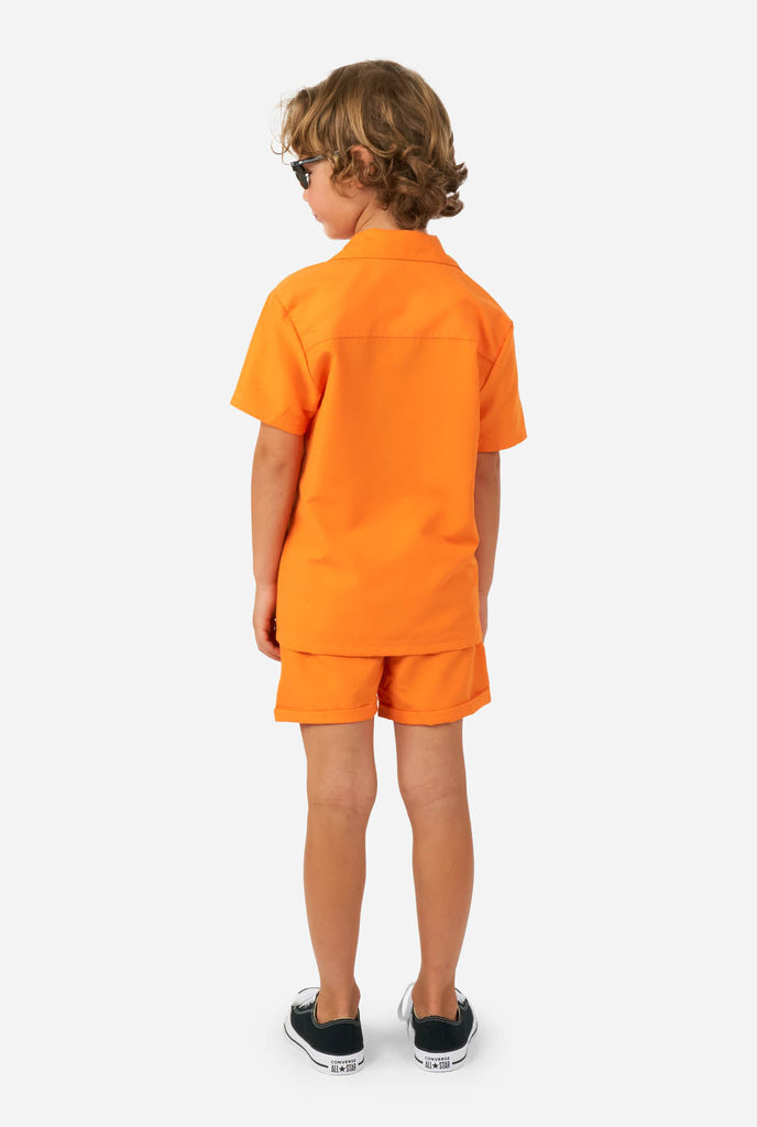 Jongen draagt oranje zomerset, bestaande uit korte broek en shirt