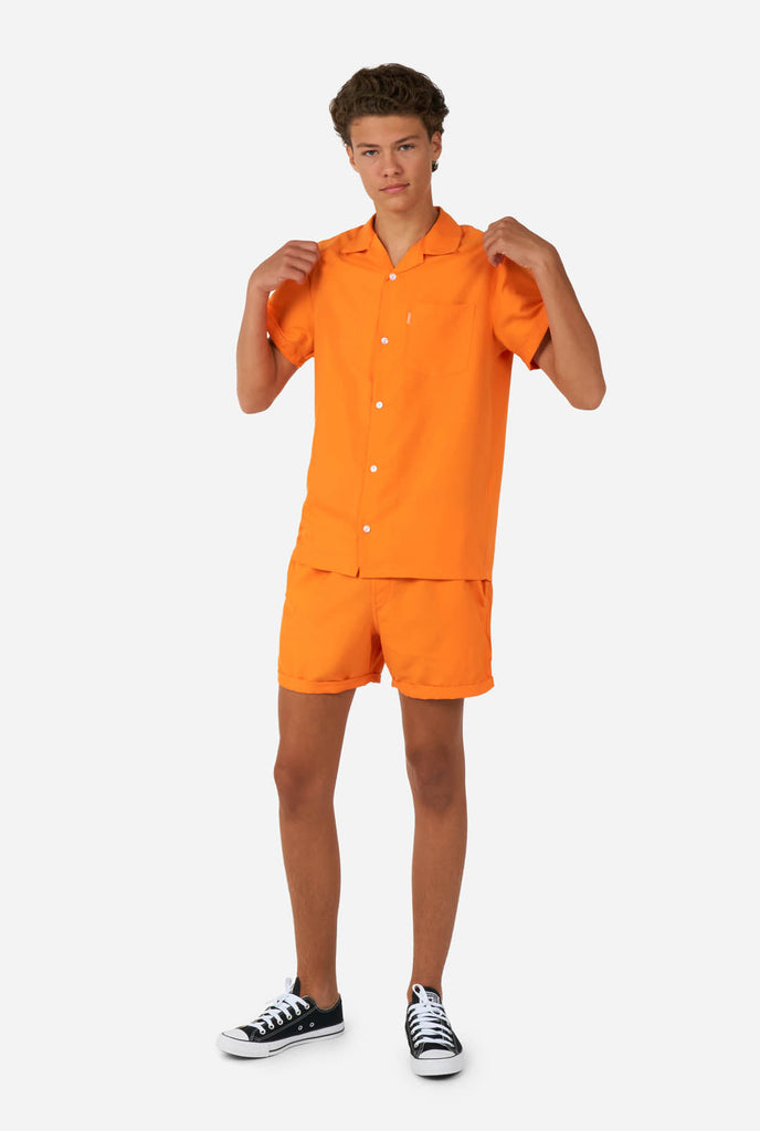 Tiener draagt oranje zomerset, bestaande uit shirt en short.