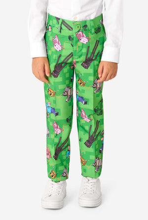 Close-up van een Minecraft-pakbroek met Creepers, varkens en wolven in een pixelachtige print, gedragen door een kind.