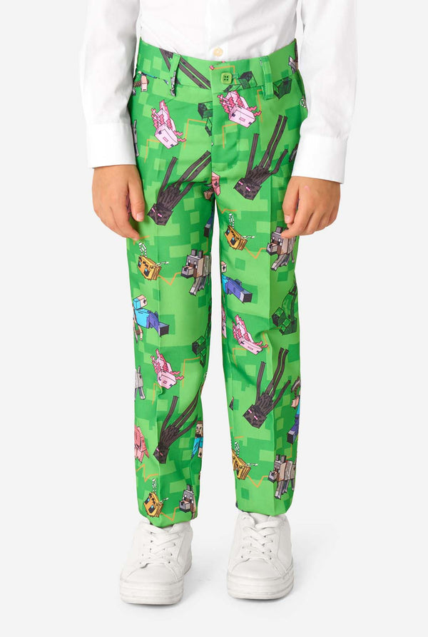 Close-up van een Minecraft-pakbroek met Creepers, varkens en wolven in een pixelachtige print, gedragen door een kind.