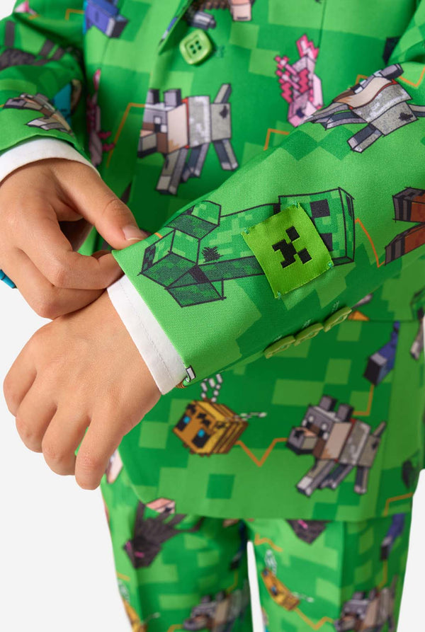 Gedetailleerde mouwclose-up van een blazer met Minecraft-thema, met de nadruk op levendige karakters en groene knopen, gedragen door een kind.