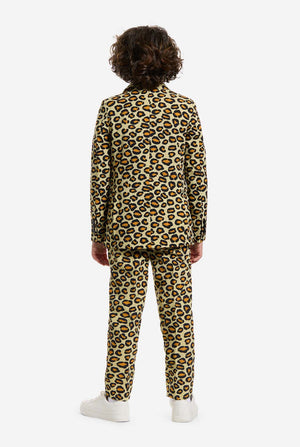 Op deze afbeelding draagt ​​een kind een jongenspak met all-over panterprint en een wit shirt. Het pak is beige met bruine en zwarte gevlekte panterprint. Pakken bestaan ​​uit een jasje, broek en clip-on stropdas. Beeld van de achterkant.