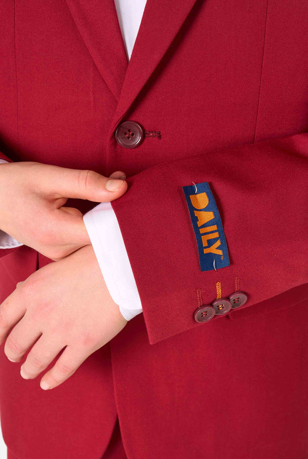 Tienerjongen draagt ​​een stijlvol bordeauxrood pak met een wit overhemd. Perfecte formele outfit voor speciale gelegenheden, bruiloften en feesten voor jongens. Close up van de mouwen.