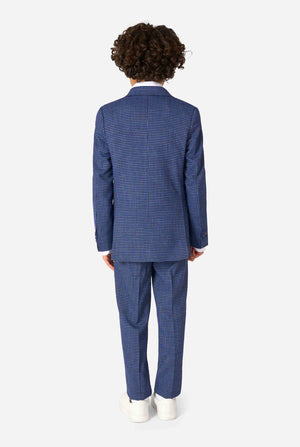 Een jongen, gekleed in een marineblauw en blauw geruit pak met een wit overhemd. Het pak heeft een moderne pasvorm met twee knopen en klepzakken. Hij staat tegen een effen witte achtergrond. Zicht vanaf de achterkant
